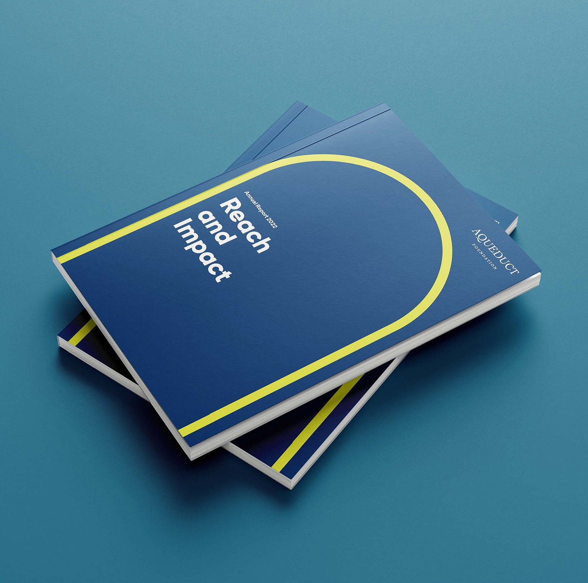 Stack of Aqueduct annual reports featuring colour palette and graphic design system designed by Intent