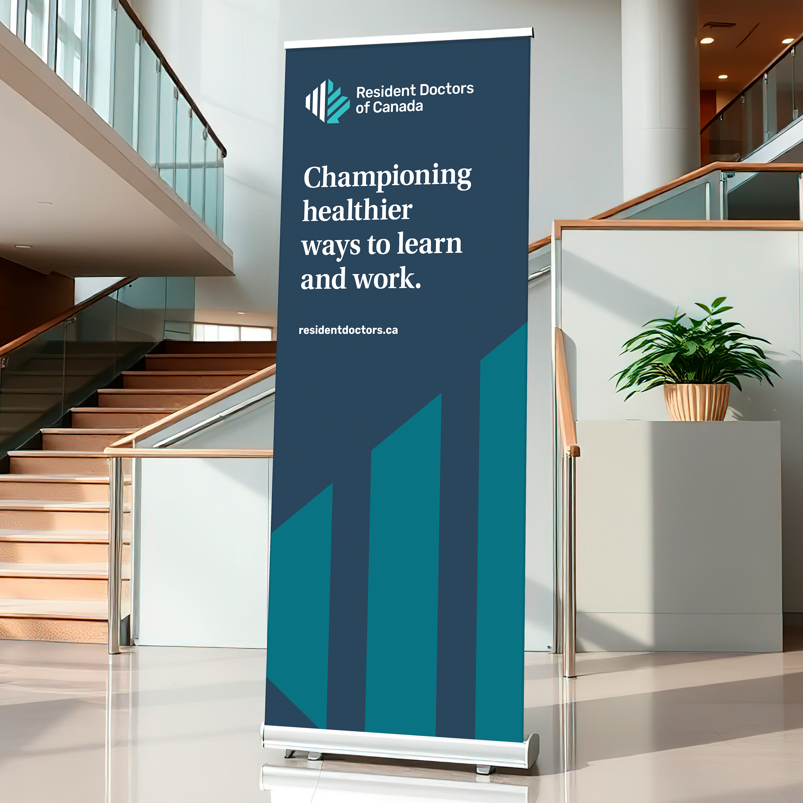 Pull-up banner for Resident Doctors of Canada displayed in a modern lobby, featuring the brand message “Championing healthier ways to learn and work” alongside the organization's visual identity.