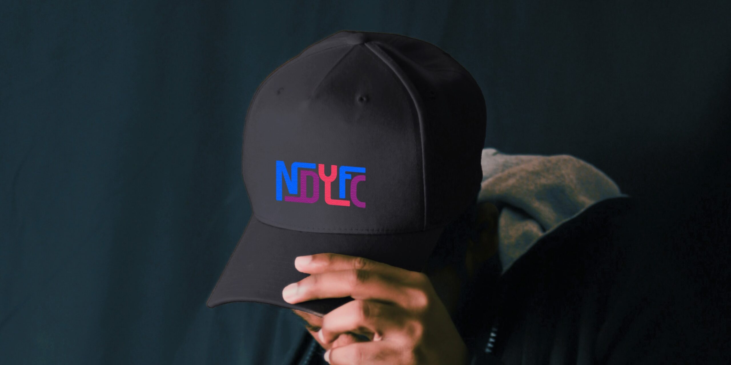 Black baseball cap embroidered with the New Dawn Youth and Family Centre logo.