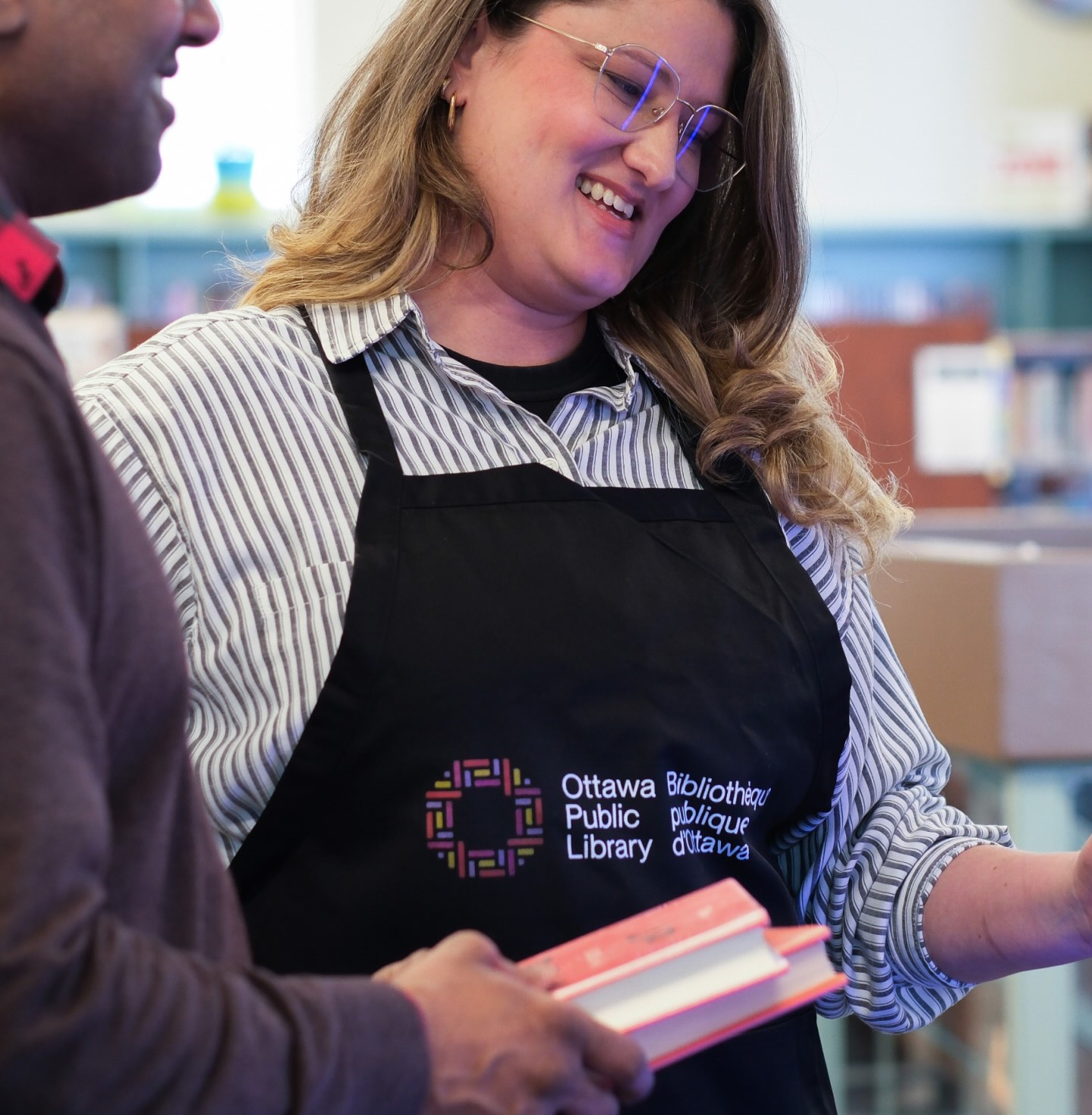 Library staff member wearing Ottawa Public Library branded from rebrand by Intent
