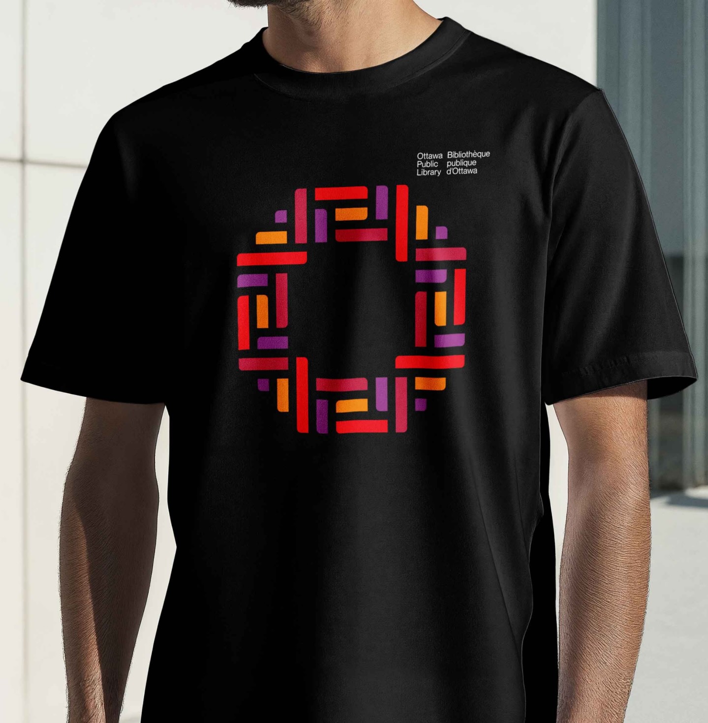 Black t-shirt featuring Ottawa Public Librarys geometric logo from brand identity designed by Intent